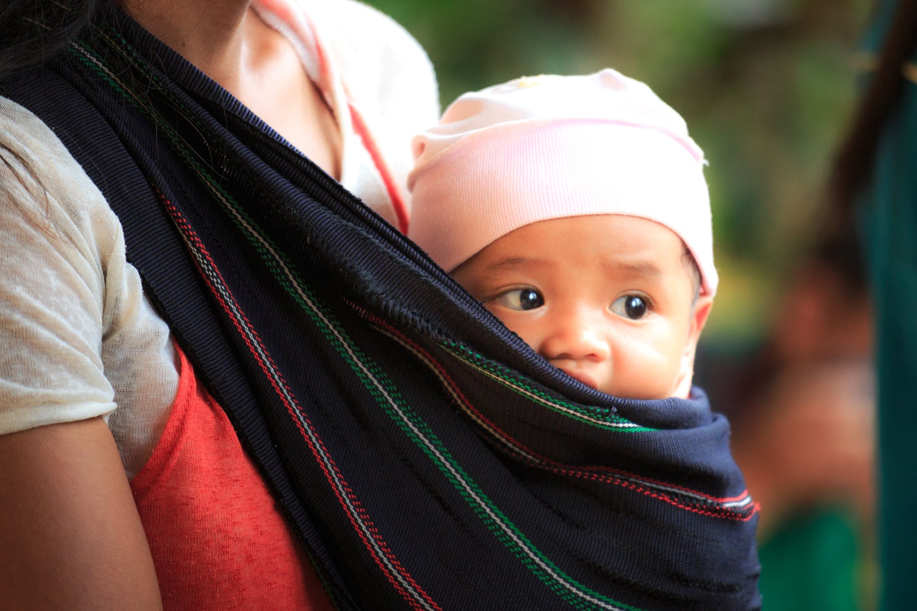 woman carrying baby in a sling